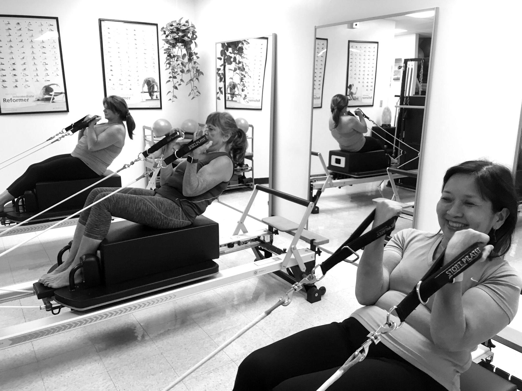 Clients working on reformers during a class